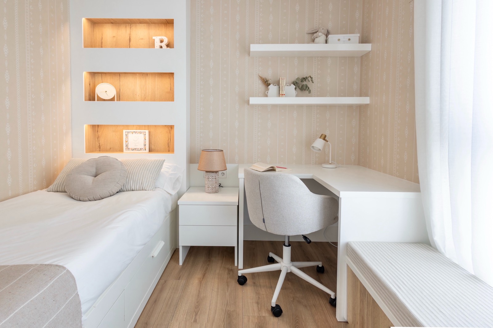 Habitación moderna minimalista con cama individual, escritorio y estanterías empotradas en tonos blancos y madera clara