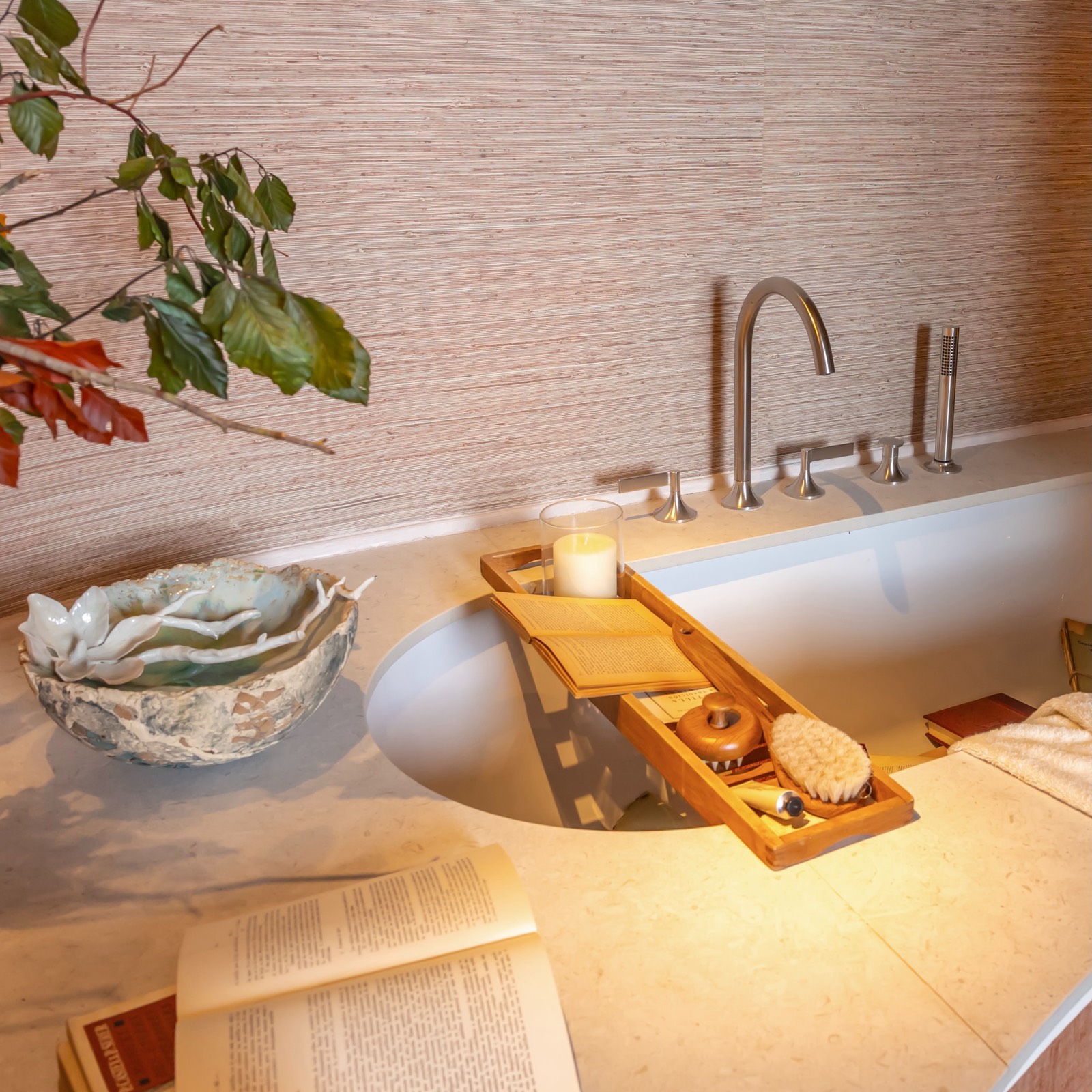Escena de baño elegante con bañera blanca, accesorios de madera, vela, cepillo y plantas decorativas con iluminación cálida